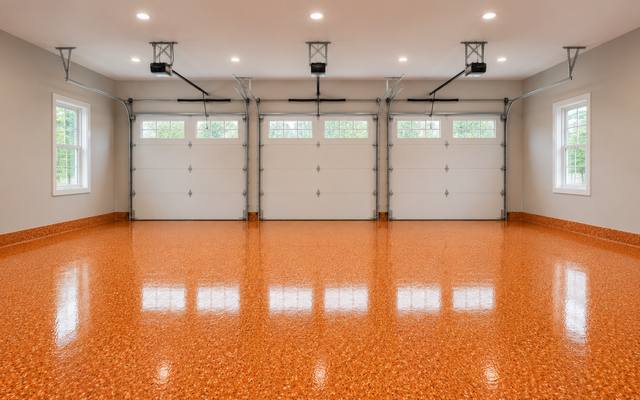 Orange flake garage floor coating running the full depth of a three bay garage